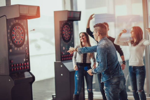 istock Young friends playing darts in a club 870186236