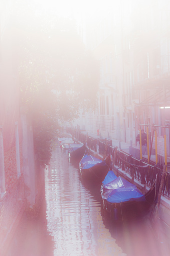 A misty venetian canal with moored gondolas