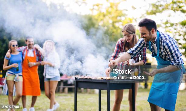 Young People Grilling Outdoors Stock Photo - Download Image Now - Barbecue - Meal, Barbecue Grill, Grilled