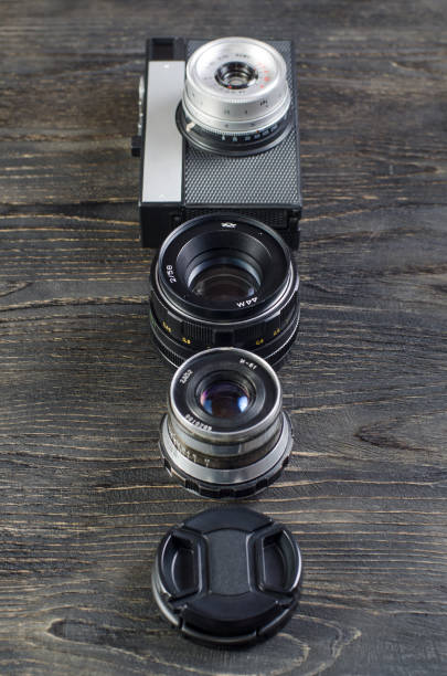 Camera lens on black background with a wooden structure