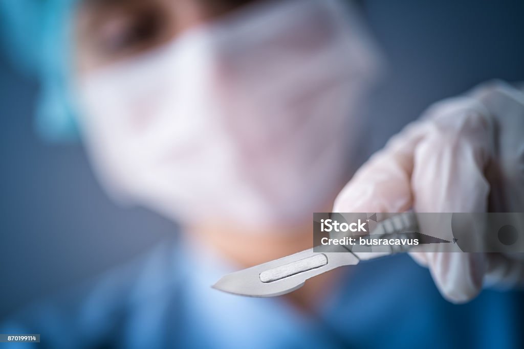 Surgeon doctor with a scalpel Surgeon scalpel, Hand, Lancet, Blue on background Scalpel Stock Photo