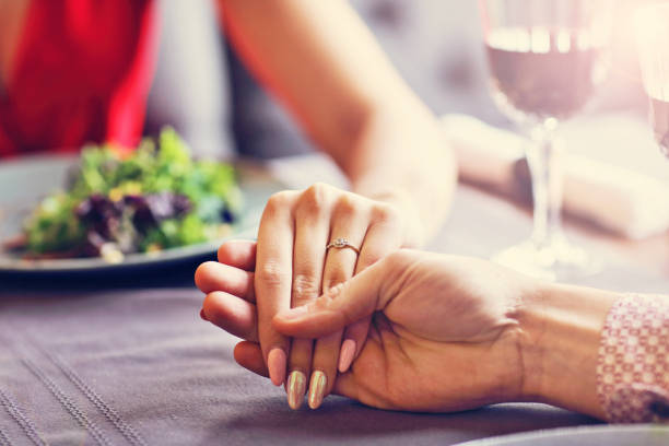 istock Couple eating romantic Dinner in a gourmet restaurant drinking wine and holding hands 870199628