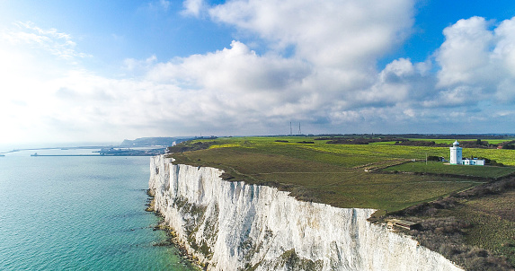 Landscape view of white cliffs of Dover from the sea,with a beautiful cloudy sky and sun