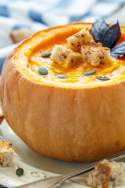 istock Pumpkin soup with croutons in a pumpkin closeup. 870219744