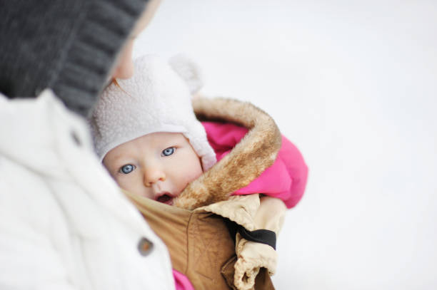 젊은 어머니와 그녀의 작은 아기를 캐리어에 - winter child coat baby girls 뉴스 사진 이미지
