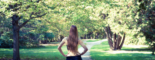 istock Panoramic freedom looking down a path from the back of a beautiful confident young woman 870227362
