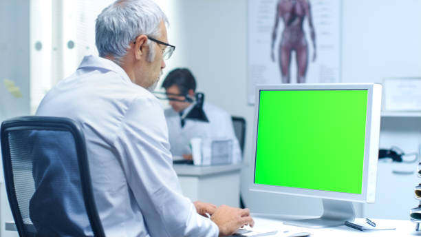 istock Senior Male Laboratory Researcher Working with Green Screen on His Personal Computer. Great for Mock up. 870233620