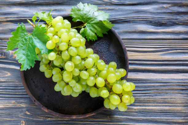 istock Bunch of white grapes on a wooden platter. 870237182