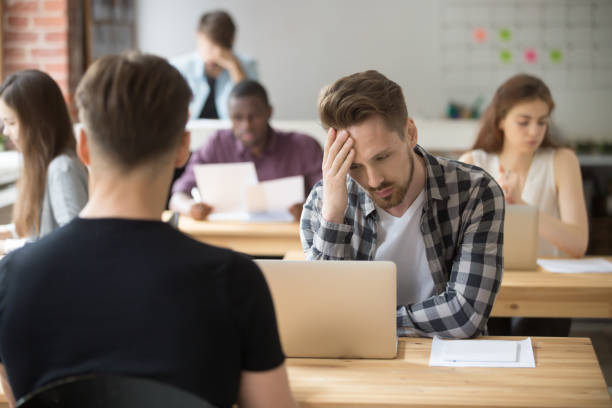 istock Puzzled young entrepreneur looking at laptop screen at workplace. 870244288