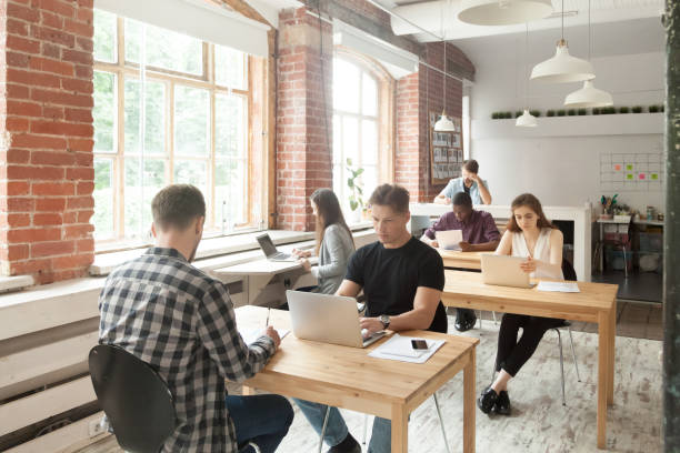 istock Young casually dressed employees at work in shared coworking office. 870244320