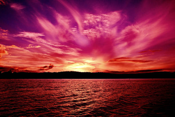 Spectacular vivid pink Orange Violet Ocean Sunset with water reflections.
