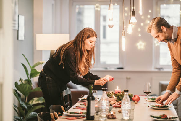 couple arranging dining table with christmas decoration