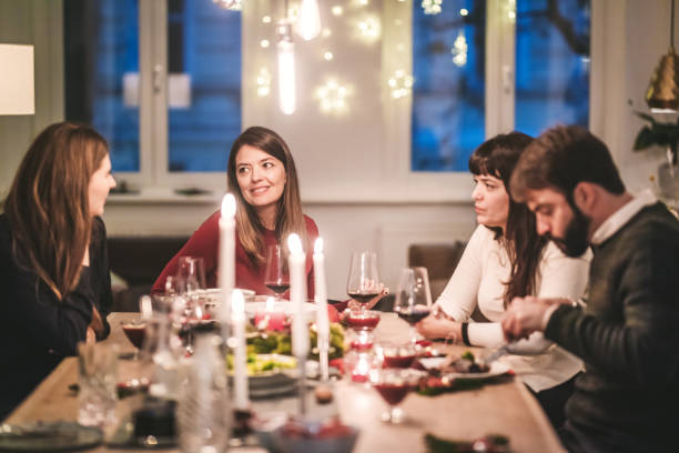 istock Friends eating and talking at christmas dinner Party 870254144