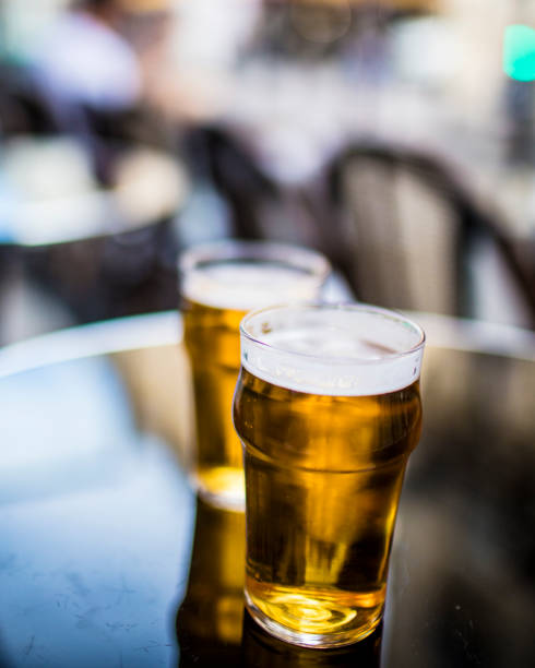 istock Two glasses of beer on a Parisian bar table. 870261416