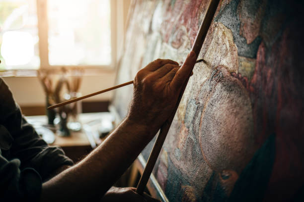 Work in the atelier. Painter finishes his picture.