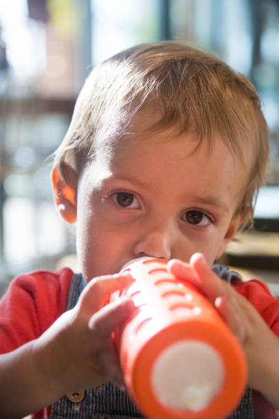 istock Male Toddler having a baby bottle 870281384