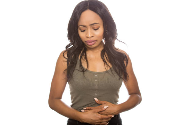 istock Sick Black female expressions on white background holding her stomach 870281526