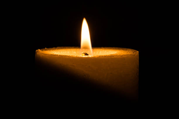 istock candle burns at dusk, a candle fire on a black background 870283808