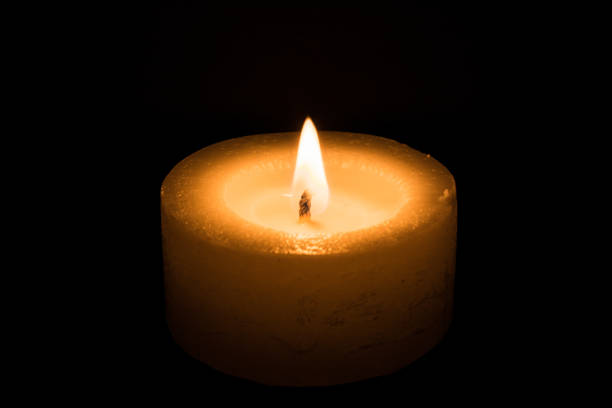 istock candle burns at dusk, a candle fire on a black background 870283894