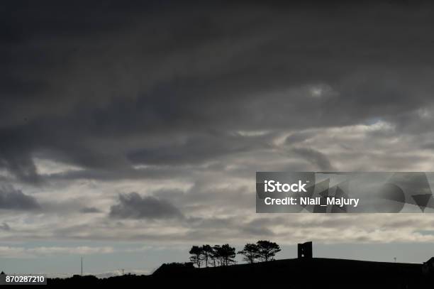 Silhouette Of Derelict Tower And Trees Against A Dramatic Sky Stock Photo - Download Image Now
