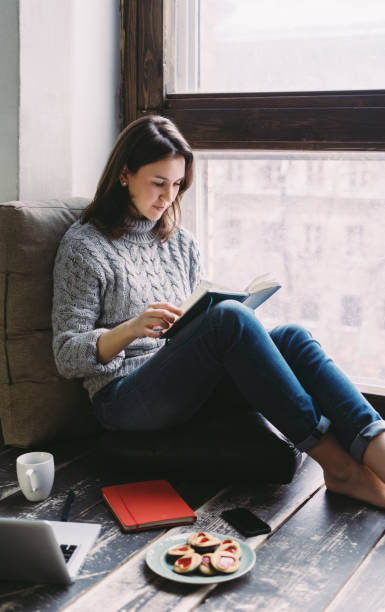 istock Young woman studying by the window 870304178