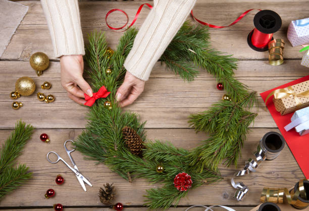 Woman making Christmas wreath. Top view stock photo