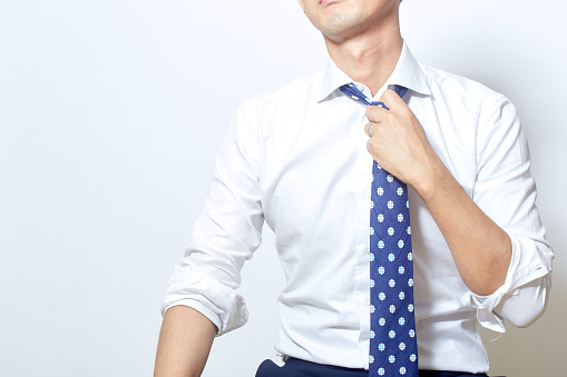 Japanese young man loosening his tie for a break
