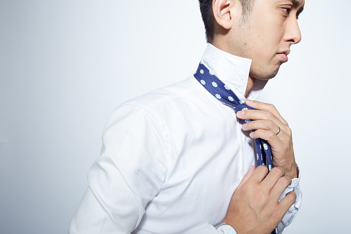 Japanese young man suiting up for work