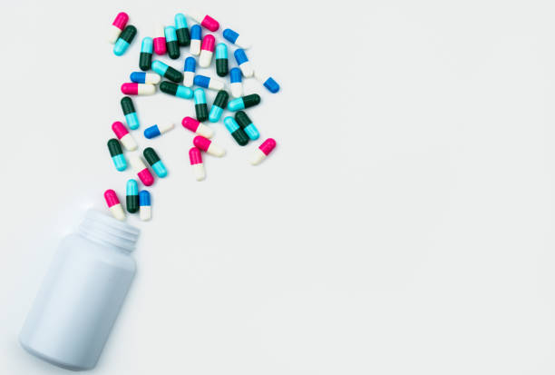 istock Pouring antibiotics capsule pills into plastic bottle isolated on white background with copy space. Drug storage, antibiotic drug use with reasonable, health policy and health insurance concept. 870354864