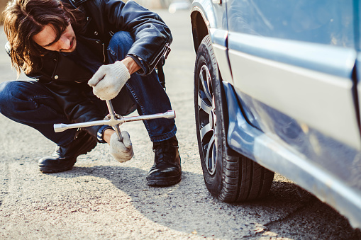 Change a flat car tire on road with Tire maintenance, damaged car tyre
