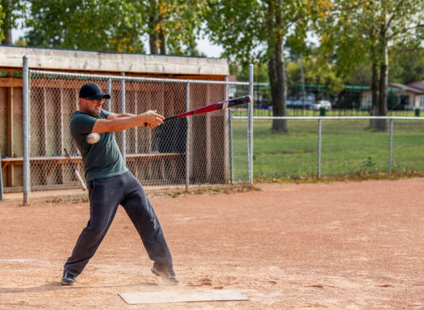 человек размахивая бейсбольной битой - baseball diamond стоковые фото и изображения