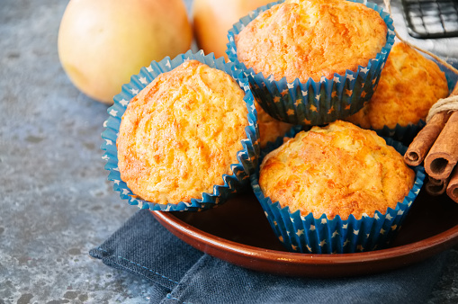 Homemade apple cheese muffins on a wire rack. Blue stone background. Seasonal baking.