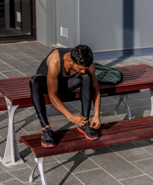 istock Man sitting on the bench tying lace 870377828