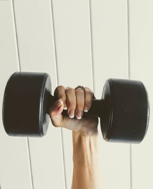 istock Female hand holding a dumbbell 870384440