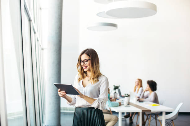 młoda bizneswoman pracująca w nowoczesnym biurze na cyfrowym tablecie - women female cheerful ecstatic zdjęcia i obrazy z banku zdjęć