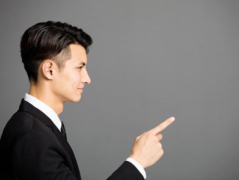 side view of business man pointing at copy space