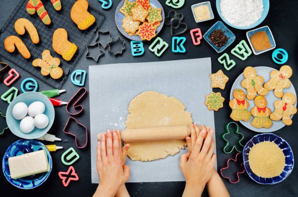 istock Women's and children's hands roll out ginger dough with ingredients for baking 870391590