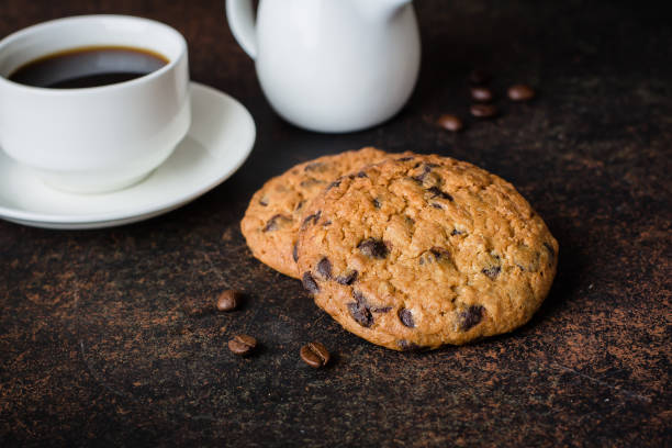 istock Coffee glass and milk with chocolate chip cookie on dark stone concrete table background. Morning Breakfast Concept. Copy space 870391704
