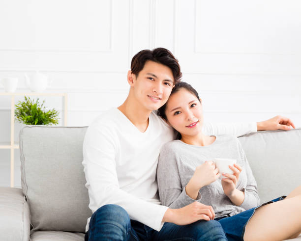 istock relaxed young asian Couple on sofa 870394212