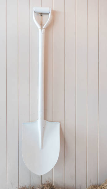 istock White shovel hanging on a white wooden wall 870394430
