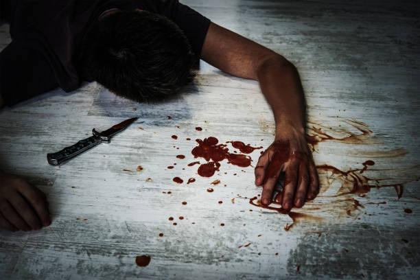 the body of a young man lying on the floor the body of a young man lying on the floor in a puddle of blood next to the murder weapon, a small folding knife. switchblade stock pictures, royalty-free photos & images
