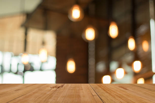 istock Wood board empty table in front of blurred coffee shop lamp background. for display or montage your product. mock up for display of product 870398122
