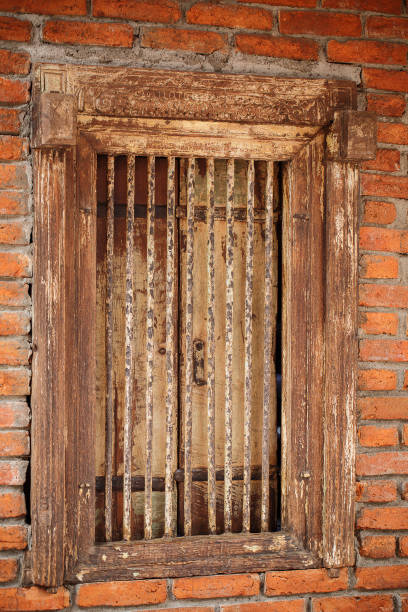 istock Old wooden window with steel cage. 870402058