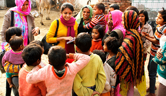 Ghaziabad, Uttar Pradesh, India- December 23, 2013: Two female social workers are interacting with a group of villagers comprising of children and female adults. They are working for the development of the village and uplifting the standard of living in the village.
