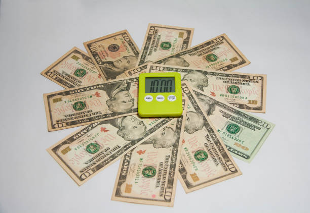 白の背景に円形の米ドル紙幣で緑プラスチック正方形ストップウォッチ。 - finance photography us currency stopwatch ストックフォトと画像