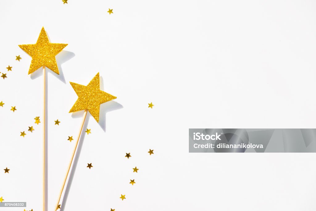 Two golden party magic wands and sequins on a white background. Copy space. Magic Wand Stock Photo