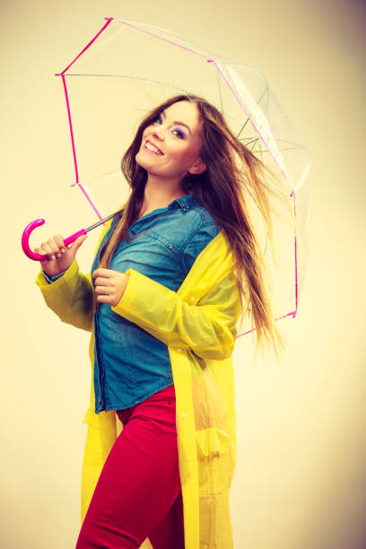 istock Woman wearing waterproof coat under umbrella 870408978