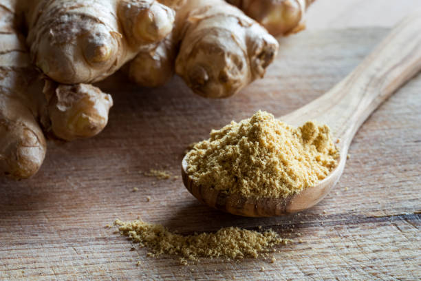 istock Ground ginger on a wooden spoon, with fresh ginger root 870411910