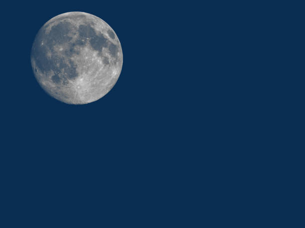 istock Full moon seen with telescope over blue 870412002