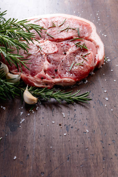 istock Raw pork with rosemary , salt and pepper. 870413056